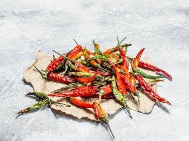 Kağıt üzerinde kurutulmuş acı biber bakla. Beyaz rustik arka plan üzerinde