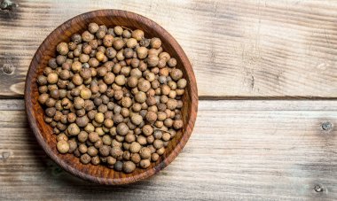 Bir kasede karabiber. Ahşap arka planda