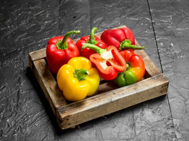 Taze tatlı biber tepsi. Rustik siyah arka plan üzerine