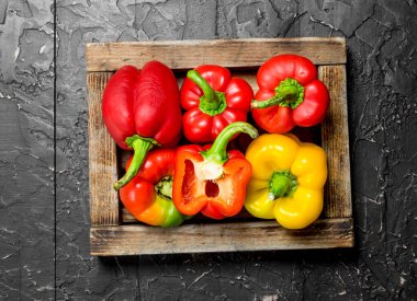 Taze tatlı biber tepsi. Rustik siyah arka plan üzerine