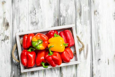 Olgun tatlı biber tepsi. Beyaz ahşap arka plan üzerinde