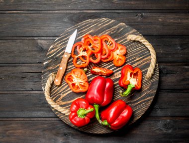 Kes ve bütün taze tatlı biber tepsi bıçakla. Ahşap arka plan üzerinde
