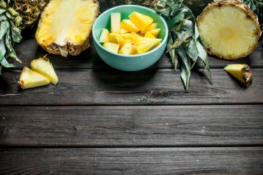 Olgun ananas bir kase kokulu dilim. Ahşap arka plan üzerinde