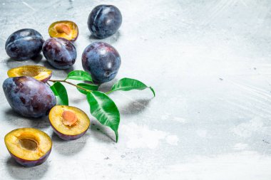 Bütün ve Erik parçalarını. Beyaz rustik arka plan üzerinde