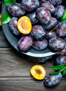 Bir tabak içinde kokulu Erik. Ahşap arka plan üzerinde