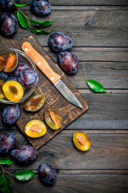 Olgun Erik üzerinde kurulu bıçak ile kesme cam kase içinde. Ahşap arka plan üzerinde