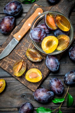 Olgun Erik üzerinde kurulu bıçak ile kesme cam kase içinde. Ahşap arka plan üzerinde