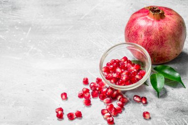 Nar tohum ve bir nar yaprakları ile. Rustik arka plan üzerinde