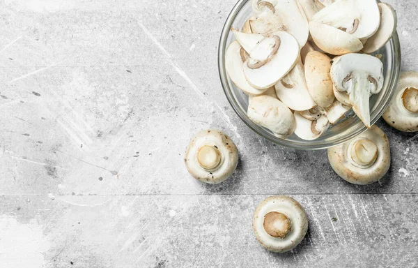 stock image Pieces of fresh mushrooms glass bowl. On rustic background