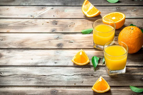 stock image Orange juice in a glass. On wooden background