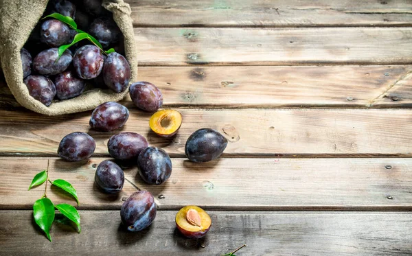 stock image Ripe plums in the sack. On wooden background