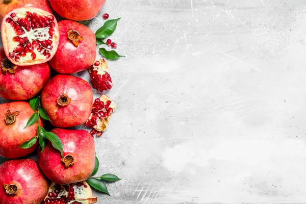 Stock image Ripe pomegranates with leaves. On white rustic background