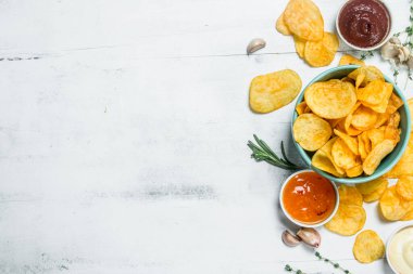 Patates cipsi soslar. Beyaz rustik arka plan üzerinde.