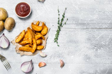 Domates soslu patates dilimleri pişmiş. Rustik bir arka plan üzerinde.