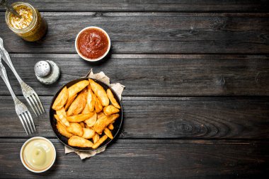 Farklı soslar ile Fırında patates dilimleri. Ahşap bir arka plan üzerinde.