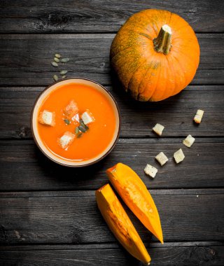 Balkabağı çorbası Peksimet ve bütün kabak kase. Ahşap arka plan üzerinde