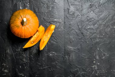 Kokulu balkabağı parçaları. Siyah rustik arka plan üzerinde