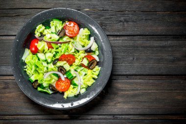 Sebze salatası. Salata, salatalık, domates ve kırmızı soğan baharat ve zeytinyağı ile. Ahşap bir arka plan üzerinde.