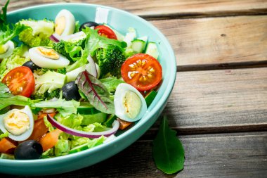 Sebze salatası. Domates, salatalık ve Bıldırcın yumurta salatası zeytinyağı ve fesleğen ile. Ahşap bir arka plan üzerinde.