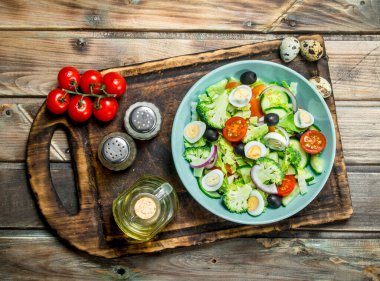 Sebze salatası. Domates, salatalık ve Bıldırcın yumurta salatası zeytinyağı ve fesleğen ile. Ahşap bir arka plan üzerinde.