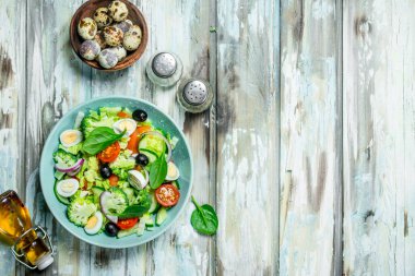 Sebze salatası. Salata, domates, salatalık ve zeytinyağı ile bıldırcın yumurtası. Rustik bir arka plan üzerinde.