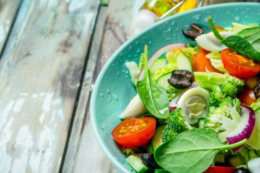 Sebze salatası. Salata, domates, salatalık ve zeytinyağı ile bıldırcın yumurtası. Rustik bir arka plan üzerinde.