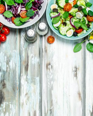 Sebze salatası. Çeşitli organik salata, sebze zeytin yağı ve baharatlar ile. Rustik bir arka plan üzerinde.