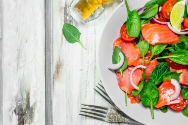 Balık salatası. Dilim somon, domates ve limon suyu ile ıspanak salatası. Rustik bir arka plan üzerinde.