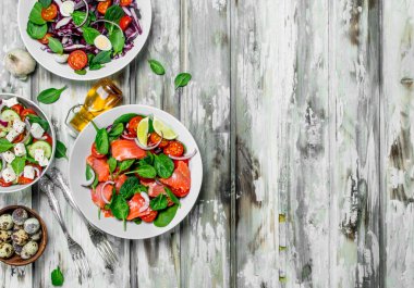 Çeşitli salatalar, organik sebze, Balık ve peynir zeytin yağı ve baharatlar ile. Rustik bir arka plan üzerinde.