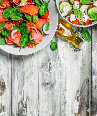 Çeşitli salatalar, organik sebze, Balık ve peynir zeytin yağı ve baharatlar ile. Rustik bir arka plan üzerinde.