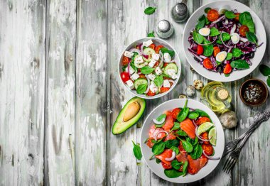 Çeşitli salatalar, organik sebze, Balık ve peynir zeytin yağı ve baharatlar ile. Rustik bir arka plan üzerinde.