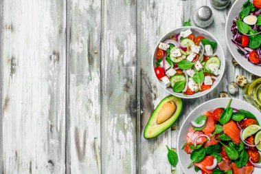 Çeşitli salatalar, organik sebze, Balık ve peynir zeytin yağı ve baharatlar ile. Rustik bir arka plan üzerinde.