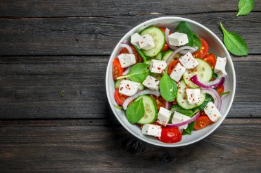 Sebze salatası. Salata sebze, peynir ve zeytin yağı ile. Ahşap bir arka plan üzerinde.