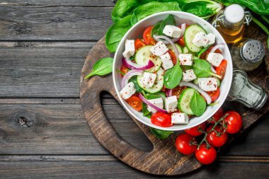 Sebze salatası. Salata sebze, peynir ve zeytin yağı ile. Ahşap bir arka plan üzerinde.