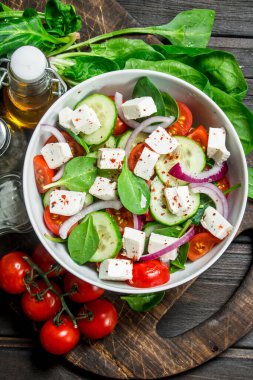 Sebze salatası. Salata sebze, peynir ve zeytin yağı ile. Ahşap bir arka plan üzerinde.