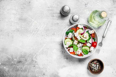 Sebze salatası. Salata sebze, peynir ve zeytin yağı ile. Rustik bir arka plan üzerinde.
