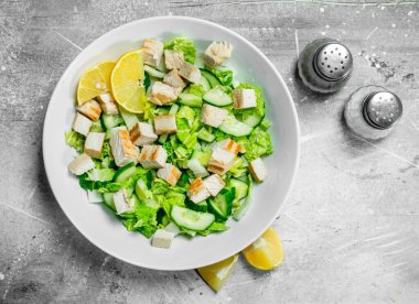 Sağlıklı salata. Salatalık, tavuk ve Çin lahanası salatası limon suyu dökülür. Rustik bir arka plan üzerinde.