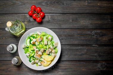 Sağlıklı salata. Salatalık, tavuk ve Çin lahanası salatası limon suyu dökülür. Ahşap bir arka plan üzerinde.