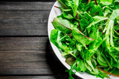 Sağlıklı salata. Roka salata bir kase. Ahşap bir arka plan üzerinde.