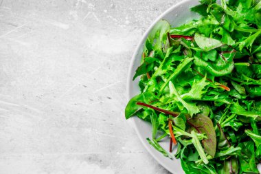 Sağlıklı salata. Roka salata bir kase. Rustik bir arka plan üzerinde.