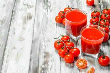 Bir cam ve dal taze domates domates suyu. Ahşap arka plan üzerinde