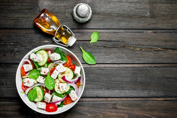 Stock image Vegetable salad. Salad with vegetables, cheese and olive oil. On a wooden background.