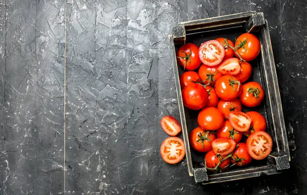 stock image Ripe red tomatoes in a box. On black rustic background