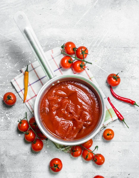 唐辛子とチェリートマトのナプキンの鍋にトマトソース 素朴な背景について — ストック写真