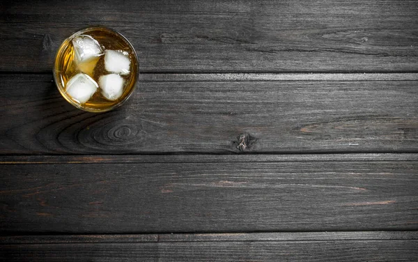威士忌在一个杯子里加冰块 在黑色木背景 — 图库照片