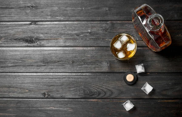 Whisky Botella Con Cubitos Hielo Sobre Fondo Madera Negro Imagen de archivo