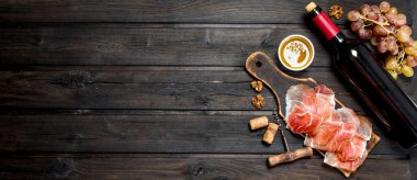 Kırmızı şarap ile geleneksel İspanyolca jambon. Ahşap bir arka plan üzerinde.