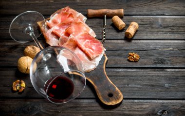 Kırmızı şarap ve fındık ile İspanyolca jambon. Ahşap bir arka plan üzerinde.