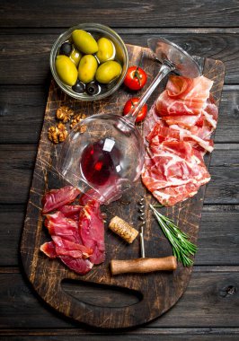 Meze arka plan. Kırmızı şarap ile farklı et aperatifler. Ahşap bir arka plan üzerinde.