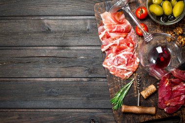 Meze arka plan. Kırmızı şarap ile farklı et aperatifler. Ahşap bir arka plan üzerinde.